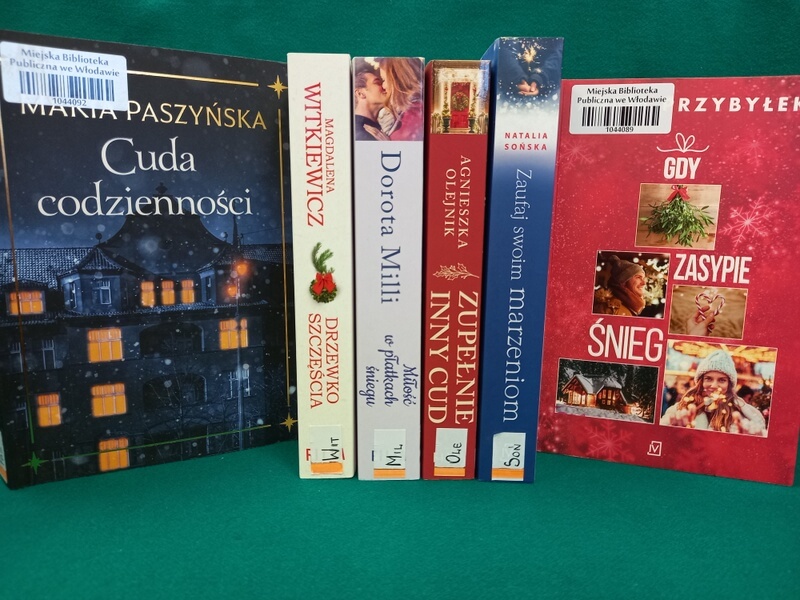 Grzbiety kilku stojących książek i okładki dwóch książek: Maria Paszyńska: Cuda codzienności; Agata Przybyłek: Gdy zasypie śnieg