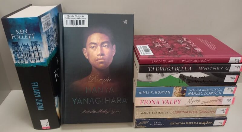Siedem książek leżących, dwie stojące, widoczna okładka: Hanya Yanagihara: Do raju.