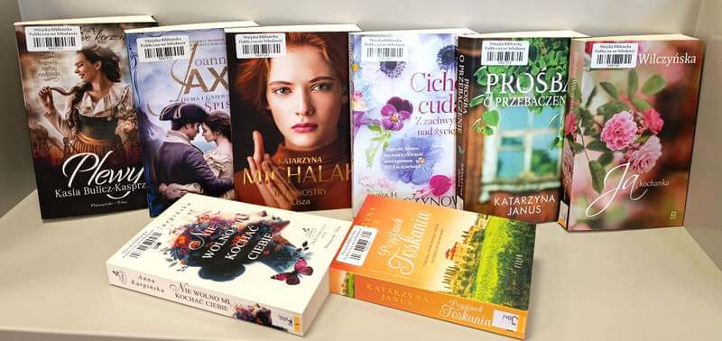 6 książek stojących, 2 książki leżące - literatura obyczajowa.
