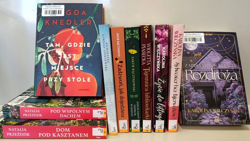 8 książek stojących, 3 książki leżące - literatura obyczajowa.